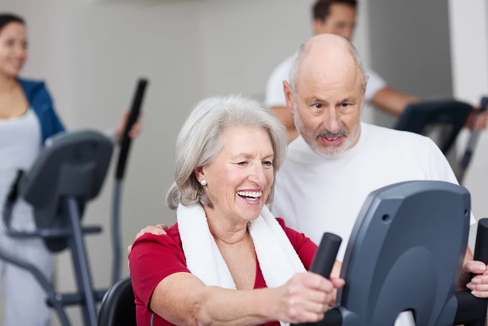 Older couple getting back in the gym and smiling